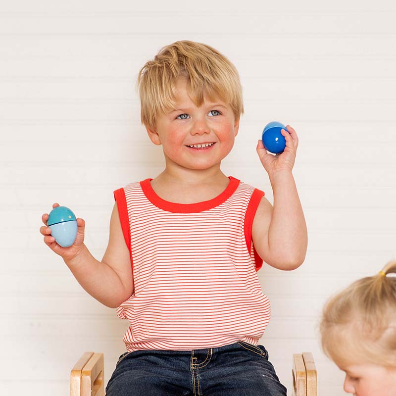 A boy is playing with the HABA Musical Eggs.