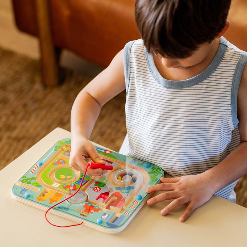 A boy is playing with the Town Maze Puzzle