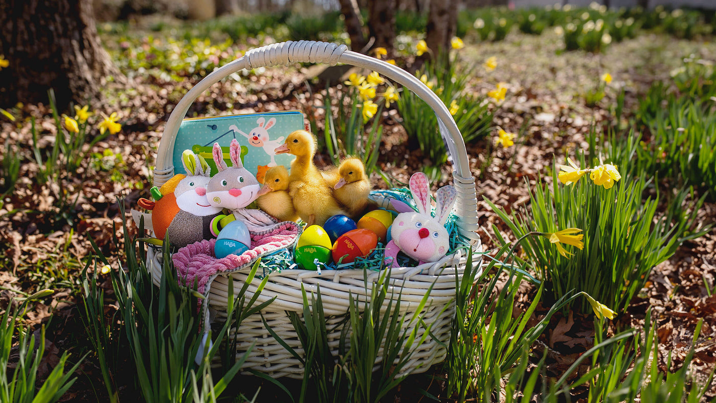 Basket sitting outside in flowers filled with HABA Easter toys